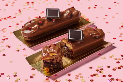 Chocolate bars with streusel, caramelized fruits and pecans on pink photo