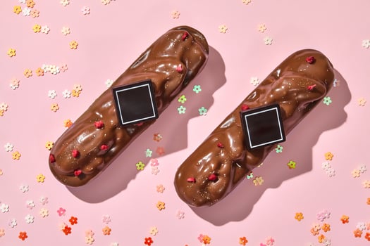 Chocolate-covered pecan bars with berry sprinkles on pink photo
