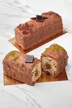 Sliced chocolate glazed loaf cake with fruit jam, berries and nuts photo