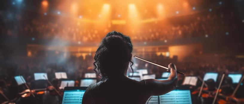 A young woman confidently leads an orchestra with a baton. Concept of musical talent. . photo