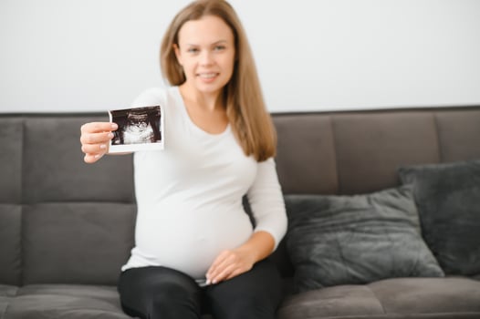 Pregnant woman hands holding ultrasound photo