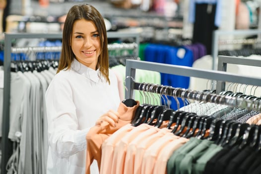 Young girl is choosing to buy clothes at the mall photo