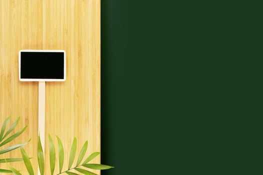 Green table and wooden kitchen board with palm leaves and chalkboard photo