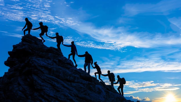 Silhouette success teamwork hold hand tightly and help each other climbing to top of mountain for goal. photo