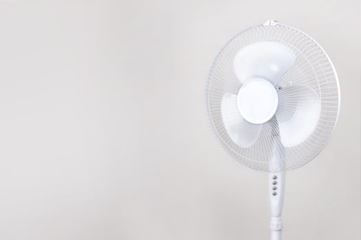 Electric Floor fan turned on white isolated on beige background. Relief Help from the heat, hot summer. Close up photo copy past