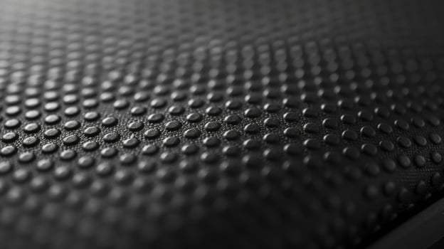 The texture of a smooth rubberized material that resembles the protective cover on a lithiumion battery providing a sy and comfortable grip photo
