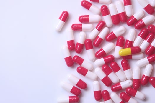close up of capsules spilling form container. photo