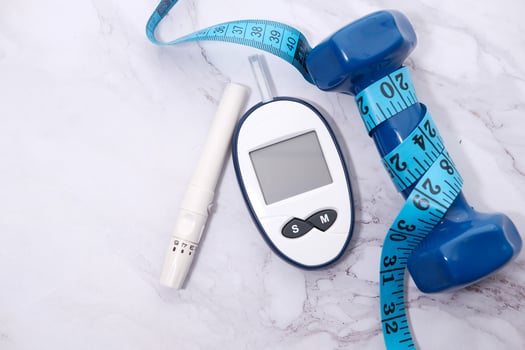 Top view glucose meter machine and dumbbell on white photo