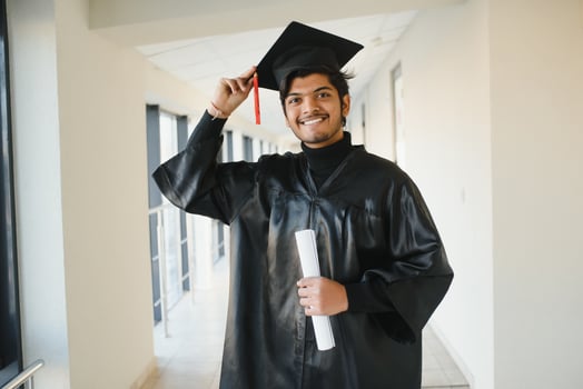 Emotional indian graduate in graduation glow and diploma. photo