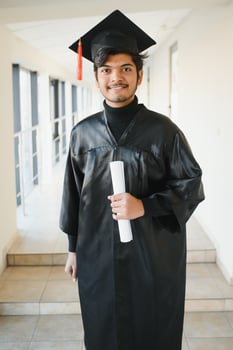 portrait of successful indian student in graduation gown. photo