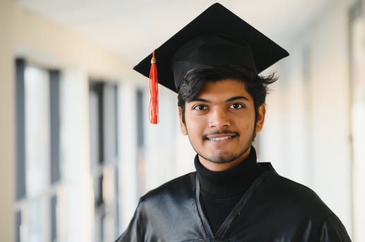 Portrait of indian handsome male graduate in graduation robe and blured background. photo