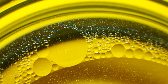 Yellow oil bubbles on water, cooking oil background. photo