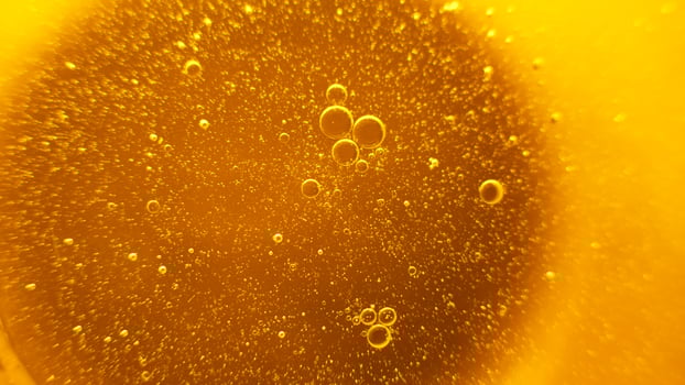 Yellow oil bubbles on water, cooking oil background. photo
