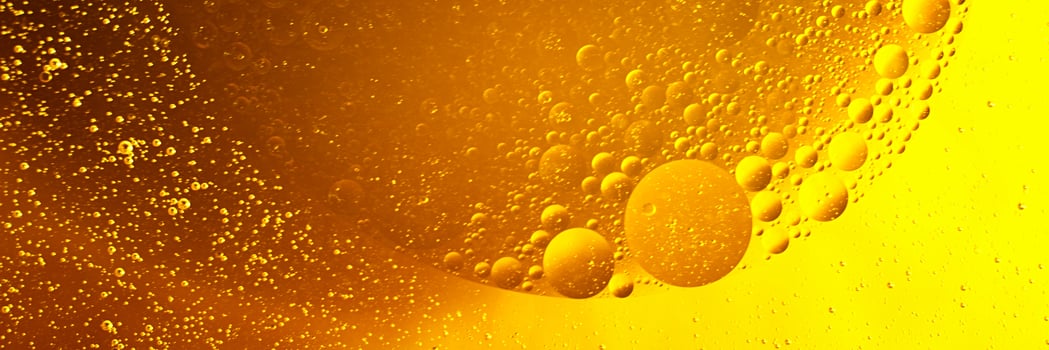 Yellow oil bubbles on water, cooking oil background. photo