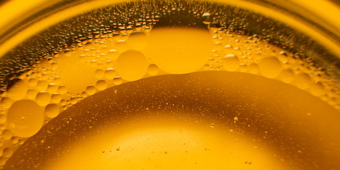 Yellow oil bubbles on water, cooking oil background. photo