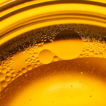 Yellow oil bubbles on water, cooking oil background. photo