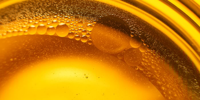 Yellow oil bubbles on water, cooking oil background. photo