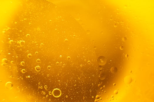 Yellow oil bubbles on water, cooking oil background. photo