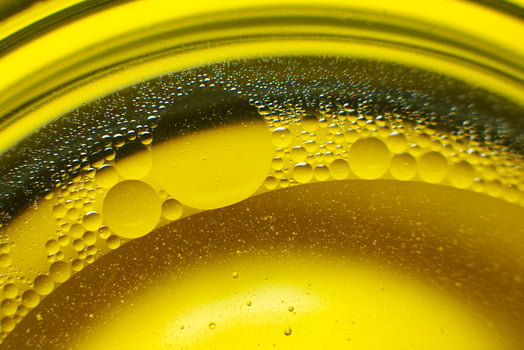 Yellow oil bubbles on water, cooking oil background. photo
