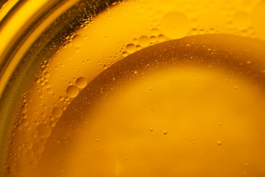 Yellow oil bubbles on water, cooking oil background. photo
