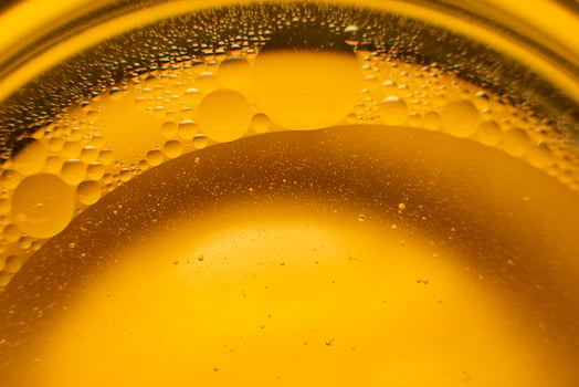 Yellow oil bubbles on water, cooking oil background. photo