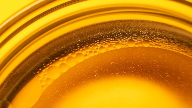 Yellow oil bubbles on water, cooking oil background. photo
