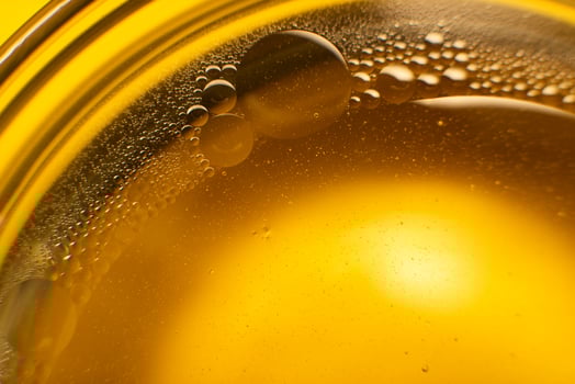 Yellow oil bubbles on water, cooking oil background. photo