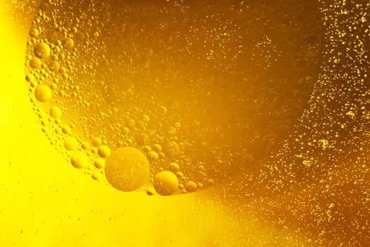 Yellow oil bubbles on water, cooking oil background. photo