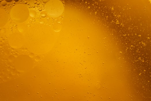 Yellow oil bubbles on water, cooking oil background. photo