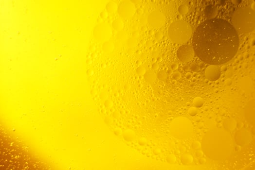 Yellow oil bubbles on water, cooking oil background. photo