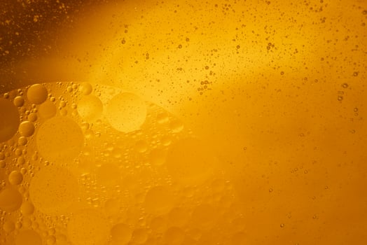 Yellow oil bubbles on water, cooking oil background. photo