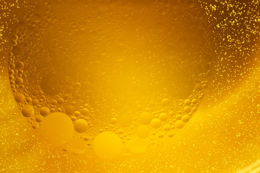 Yellow oil bubbles on water, cooking oil background. photo