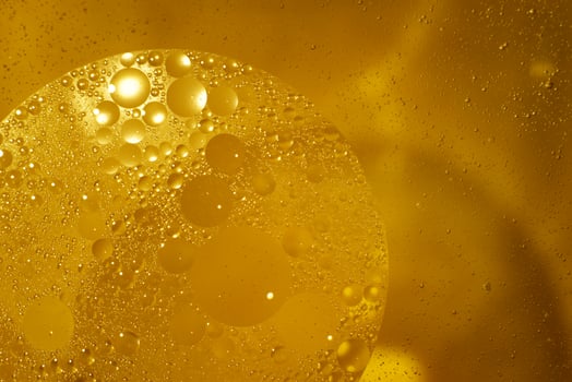 Yellow oil bubbles on water, cooking oil background. photo