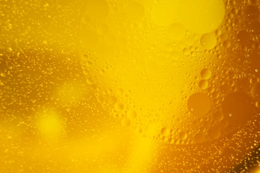 Yellow oil bubbles on water, cooking oil background. photo