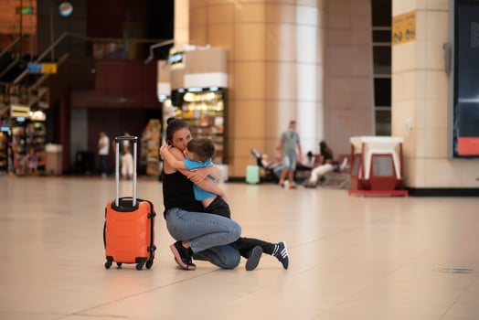 Family at airport before flight. Mother and son waiting to board at departure gate of modern international terminal. Traveling and flying with children. Mom with baby and toddler boarding airplane. photo