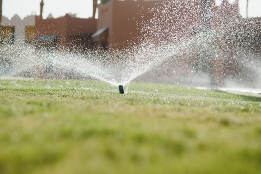 Modern device of irrigation garden. Irrigation system - technique of watering in the garden. Lawn sprinkler spraying water over green grass. photo