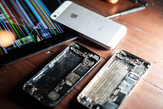 Disassembled smartphone and damaged tablet on wooden surface photo