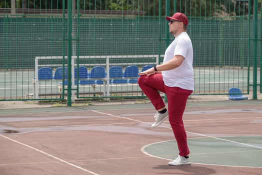 Athletic bearded man warms up before workout at the stadium photo