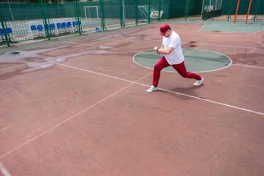 Athletic bearded man warms up before workout at the stadium photo
