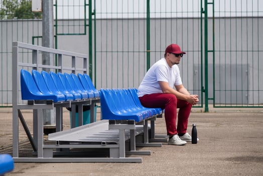 sportsman with a bottle of water sitting and resting at the seats at the stadium photo