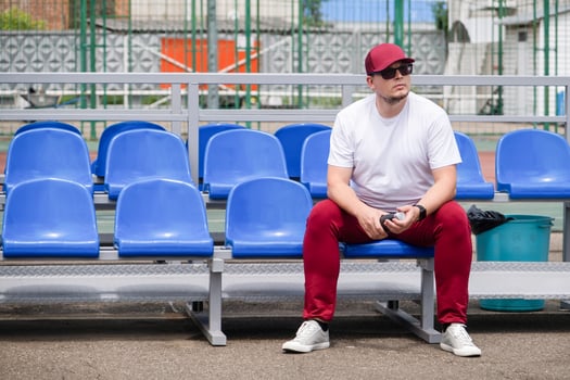 sportsman with a bottle of water sitting and resting at the seats at the stadium photo