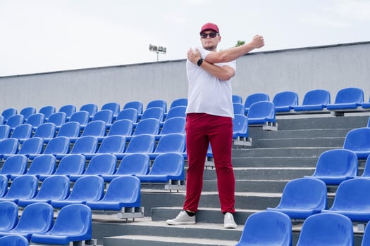 sportsman running in the stadium among blue seats photo