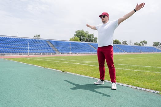 Athletic bearded man warms up before workout at the stadium photo