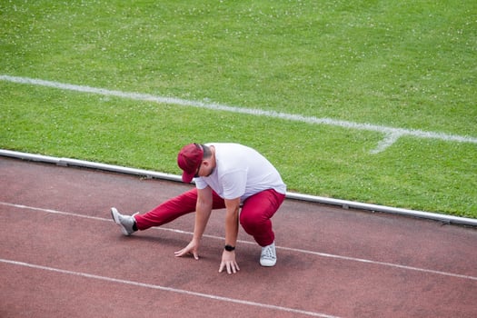 Athletic bearded man warms up before workout at the stadium photo