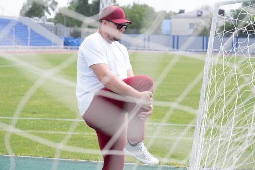Athletic bearded man warms up before workout at the stadium photo