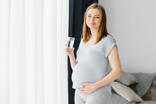 Portrait of a lovely pregnant woman drinking water photo