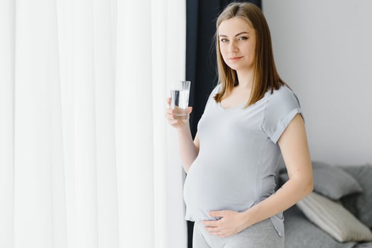 Portrait of a lovely pregnant woman drinking water photo