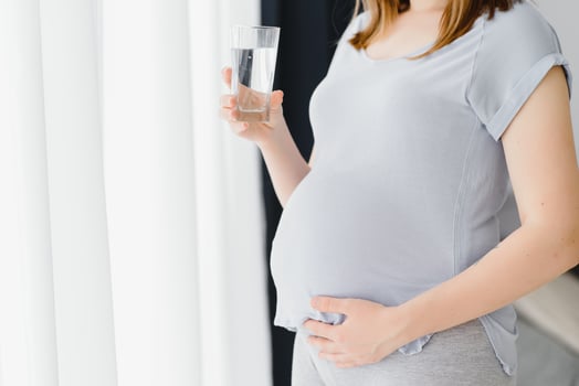 Portrait of a lovely pregnant woman drinking water photo