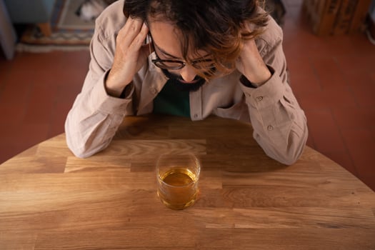 Upset young man drinker alcoholic with glass whiskey alone, alcohol addiction abuse, photo