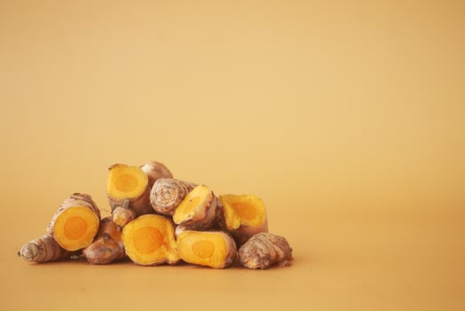 turmeric roots on a orange color background with copy space photo